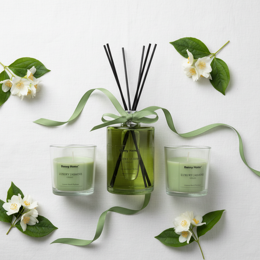 Overhead flat lay of Danny Home Luxury Jasmine candles and reed diffuser on white linen with jasmine flowers